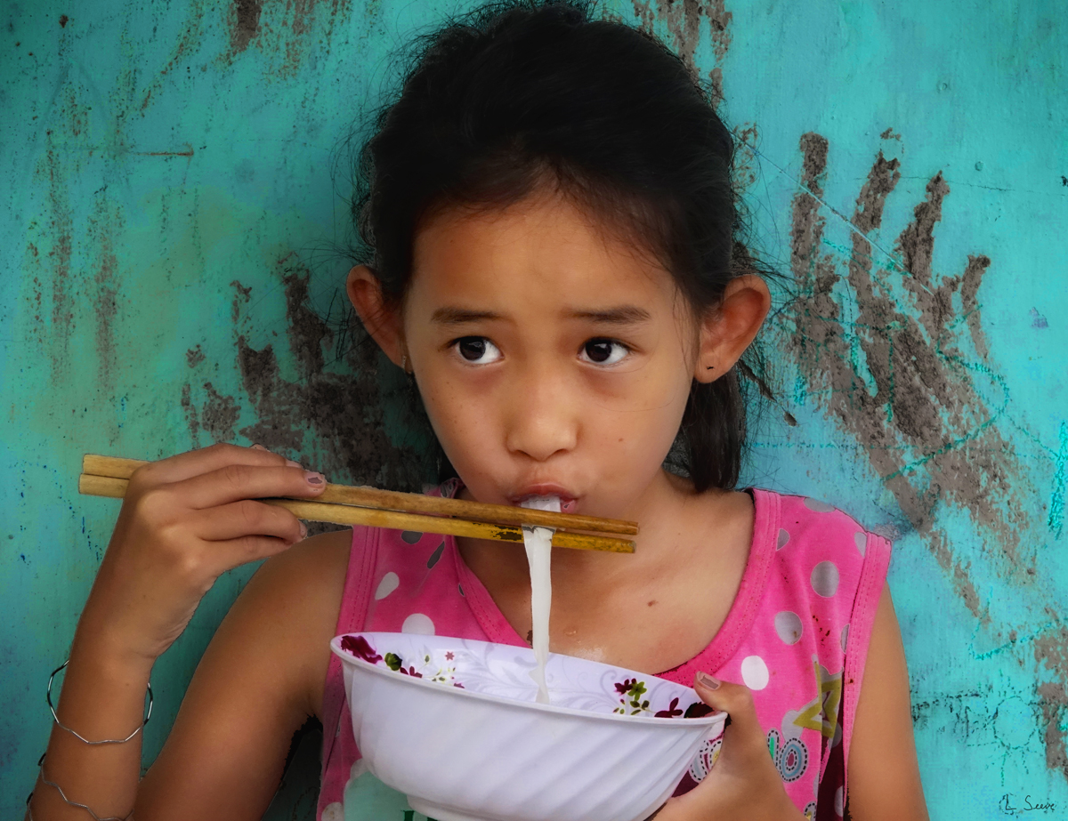 Vietnamese Girl Eating Noodles, Digital Photograph by Len Seeve